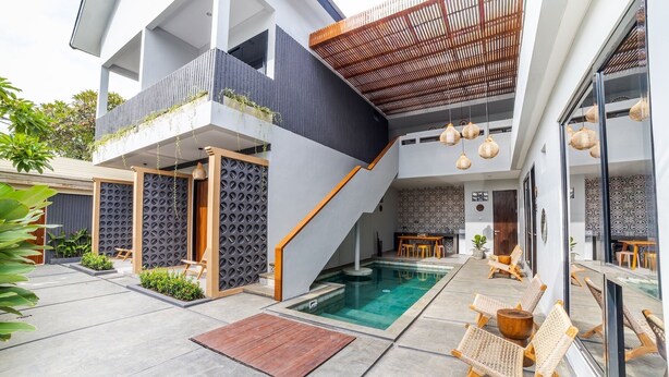 A modern house with a pool, outdoor seating, and a covered patio area. - Padinis Villa & Coffee (Sukawati)