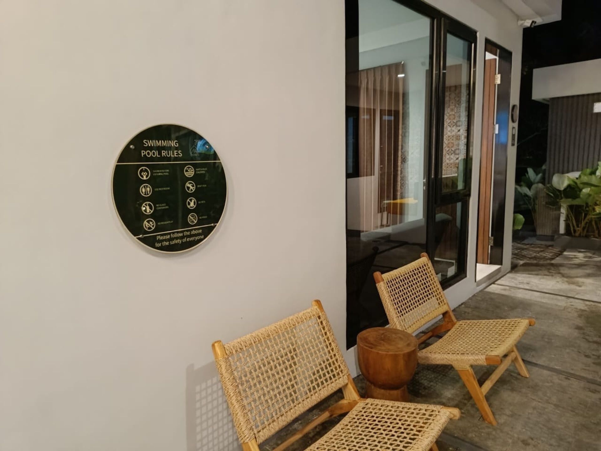 Señal circular con normas de la piscina en una pared.
