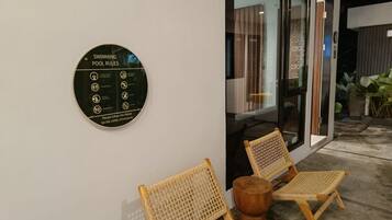 Señal circular con normas de la piscina en una pared.