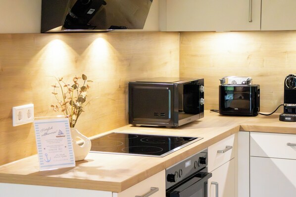 A modern kitchen with a built-in stove, a microwave, and a coffee maker.
