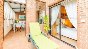A balcony with a green lounge chair, a potted plant, and a view of the interior. - Bright Penthouse with Views in Calpe (Calpe)