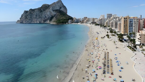 A coastal cityscape with a prominent rocky cliff, a sandy beach with umbrellas, and high-rise buildings. - Bright Penthouse with Views in Calpe (Calpe)