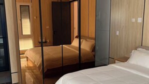 A modern bedroom with a large bed, a walk-in closet, and a mirrored wardrobe. - Beach Front 4 Bed Condon D2.1 with Sea View and Private Pool !! (Simpson Bay)