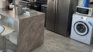 A modern kitchen with a central island, stainless steel appliances, and a built-in washing machine. - Beach Front 4 Bed Condon D2.1 with Sea View and Private Pool !! (Simpson Bay)