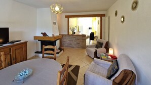 A cozy living room with a fireplace, a television, and a dining area. - Charming holiday home in Chauffayer - 4 pers - Aubessagne (Aubessagne)