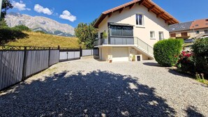 A two-story house with a balcony, a gravel driveway, and a mountain backdrop. - Charming holiday home in Chauffayer - 4 pers - Aubessagne (Aubessagne)