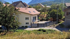A residential area with houses, a paved driveway, and a mountain in the background. - Charming holiday home in Chauffayer - 4 pers - Aubessagne (Aubessagne)