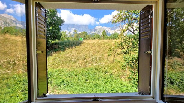 A window with a view of a grassy field and mountains in the distance. - Charming holiday home in Chauffayer - 4 pers - Aubessagne (Aubessagne)