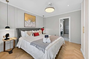 A hotel room with a large bed, a bedside table, a wall-mounted artwork, and a ceiling light fixture. - Seashell Diamond Luxury Suite (Playa San Juan)