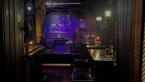 An interior view of a bar with a stage, bar stools, and a wooden ceiling. - Parkhotel Essen (Essen)