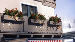 Un immeuble doté de balcons décorés de guirlandes et d’ornements de Noël.