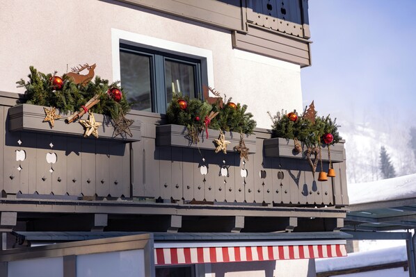 A building with balconies decorated with Christmas wreaths and ornaments. - Schwaiger Appartements Zell am See (Zell am See)