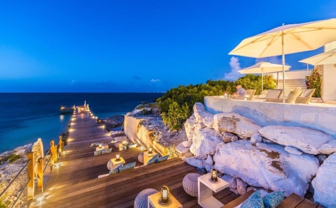 Sip cocktails above the water as the pier glows.