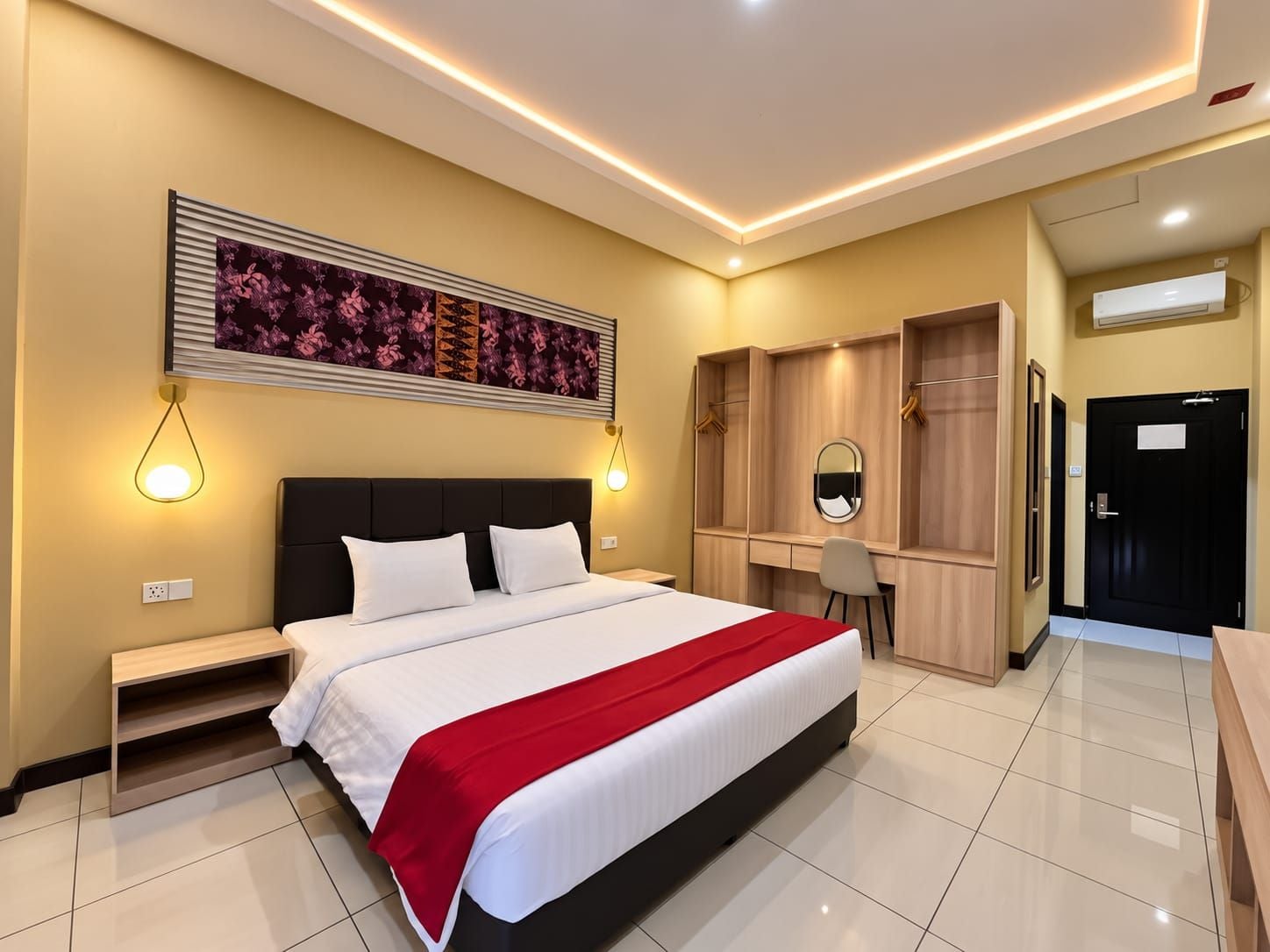 Habitación de hotel con una cama grande, mesitas de noche, un escritorio con silla, un armario y un espejo.