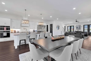 A modern kitchen with white cabinets, a central island, and pendant lighting. - Lakefront Farmhouse | 14 Guests | Tims Ford Lake (Winchester)