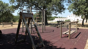 Un parque infantil con estructuras para escalar y columpios.