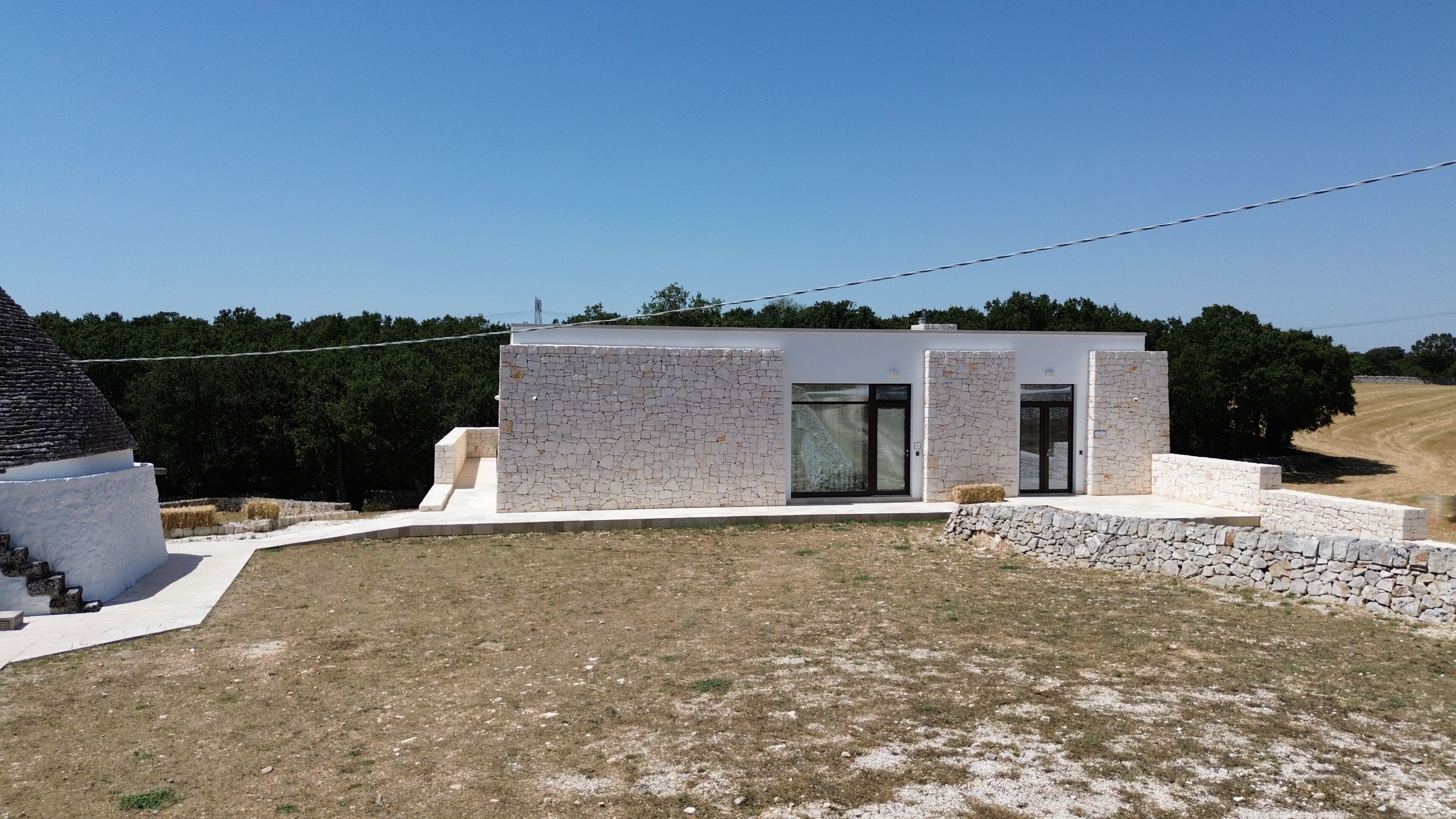 Un edificio moderno con fachada de piedra, ventanas grandes y techo plano.