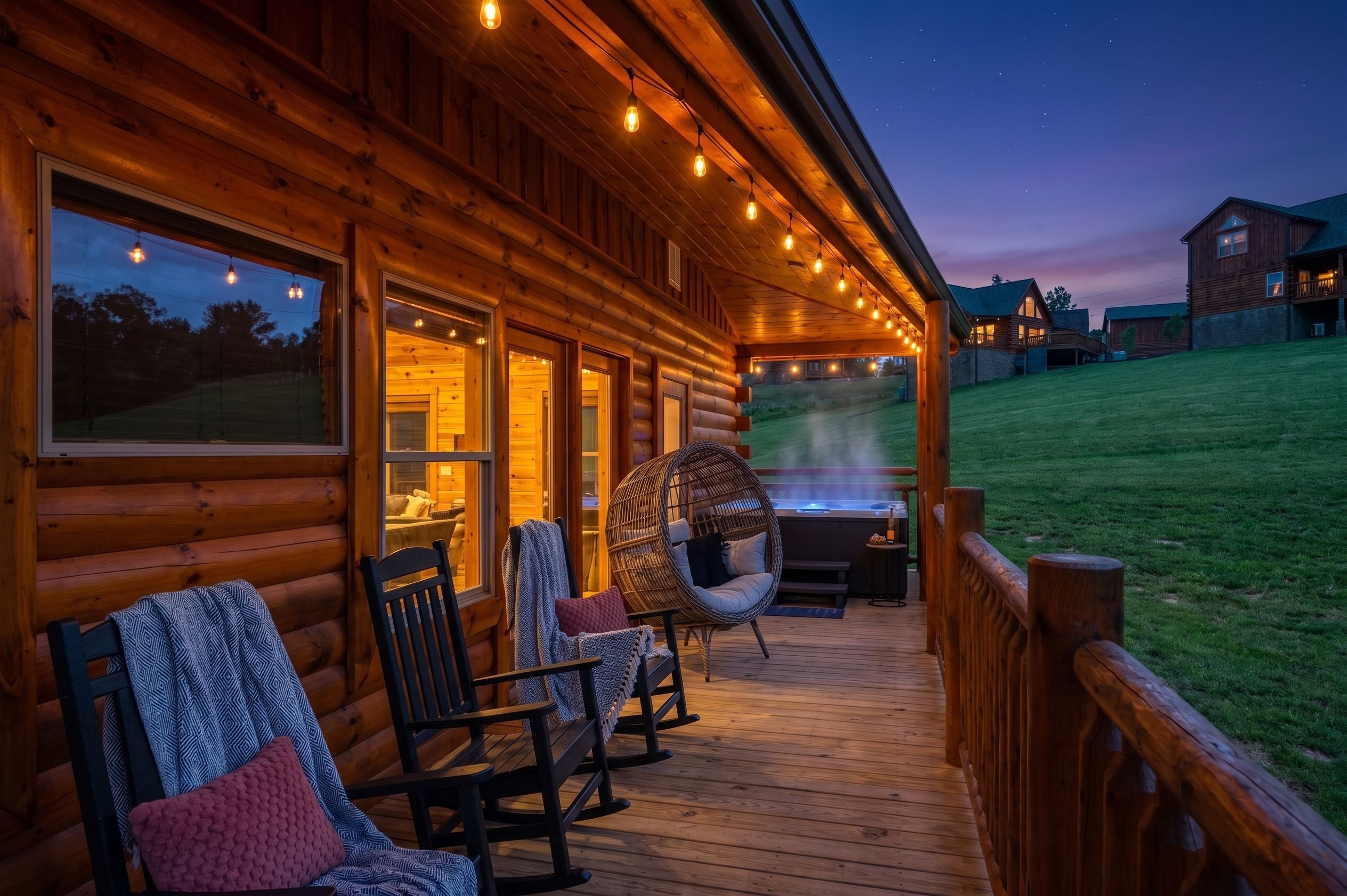 Eine Holzhütte mit einer Terrasse, Schaukelstühlen und einem Whirlpool.