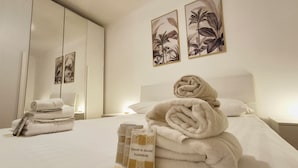 Una habitación de hotel con una cama, un espejo y obras de arte en las paredes.