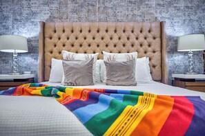 A neatly made bed with a tufted headboard, two bedside tables with lamps, and a colorful blanket. - Luxurious Condo at SOHO with Panoramic Romantic Zone Views (Puerto Vallarta)