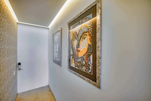 A hallway with two framed artworks on the walls and a patterned door. - Luxurious Condo at SOHO with Panoramic Romantic Zone Views (Puerto Vallarta)