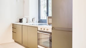 A modern kitchen with a built-in oven and a window above the sink.