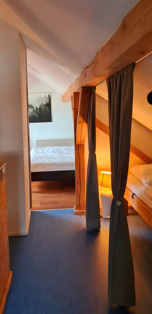 A bedroom with a bed, a nightstand, a lamp, and a painting on the wall.