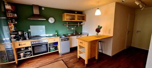Una cocina compacta con estufa, horno, pileta y gabinetes de madera.