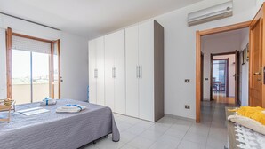 A bedroom with a bed, a wardrobe, a desk, and a window. - Casa Gialla (Alghero)
