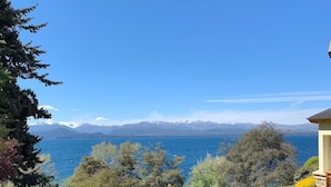 A pathway leading to a house with a view of a lake and mountains.