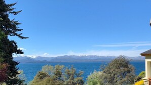 Un sendero que lleva a una casa con vista a un lago y montañas.