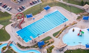 A large swimming pool with a water slide, a separate kiddie pool, and a small hot tub area.
