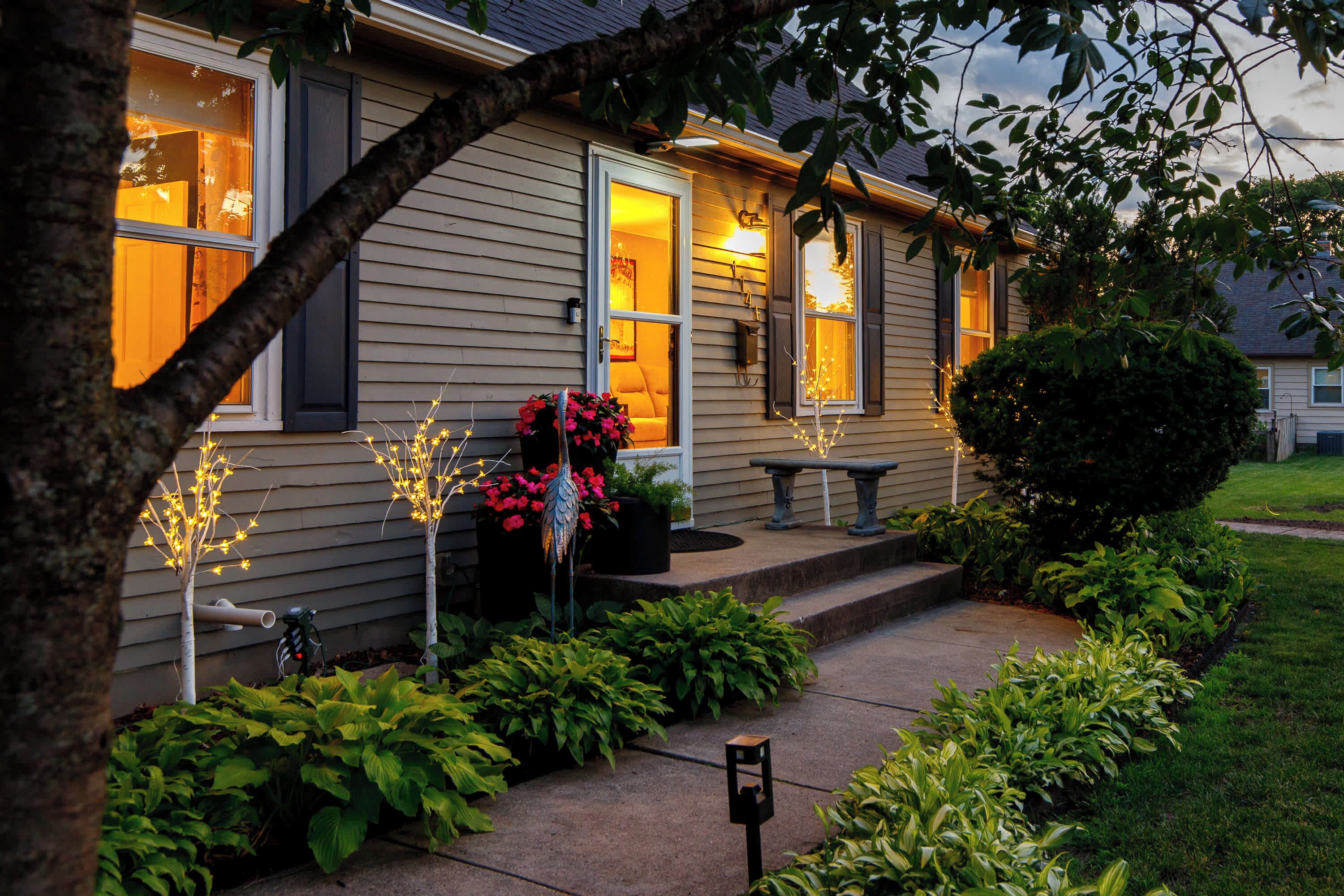 A house with a front porch, steps, and a pathway leading to the entrance.