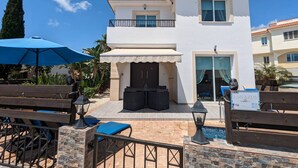 A two-story building with a balcony, a pool, and outdoor seating. - Ennazuse - Beautiful 2 Bedroom Villa in Pernera (Paralimni)