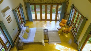 A room with a bed, a small table, two chairs, and a view of the outdoors. - Moonbow Lodge (Lake Manyara National Park)