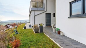 A modern building with a balcony, a door, and a window.
