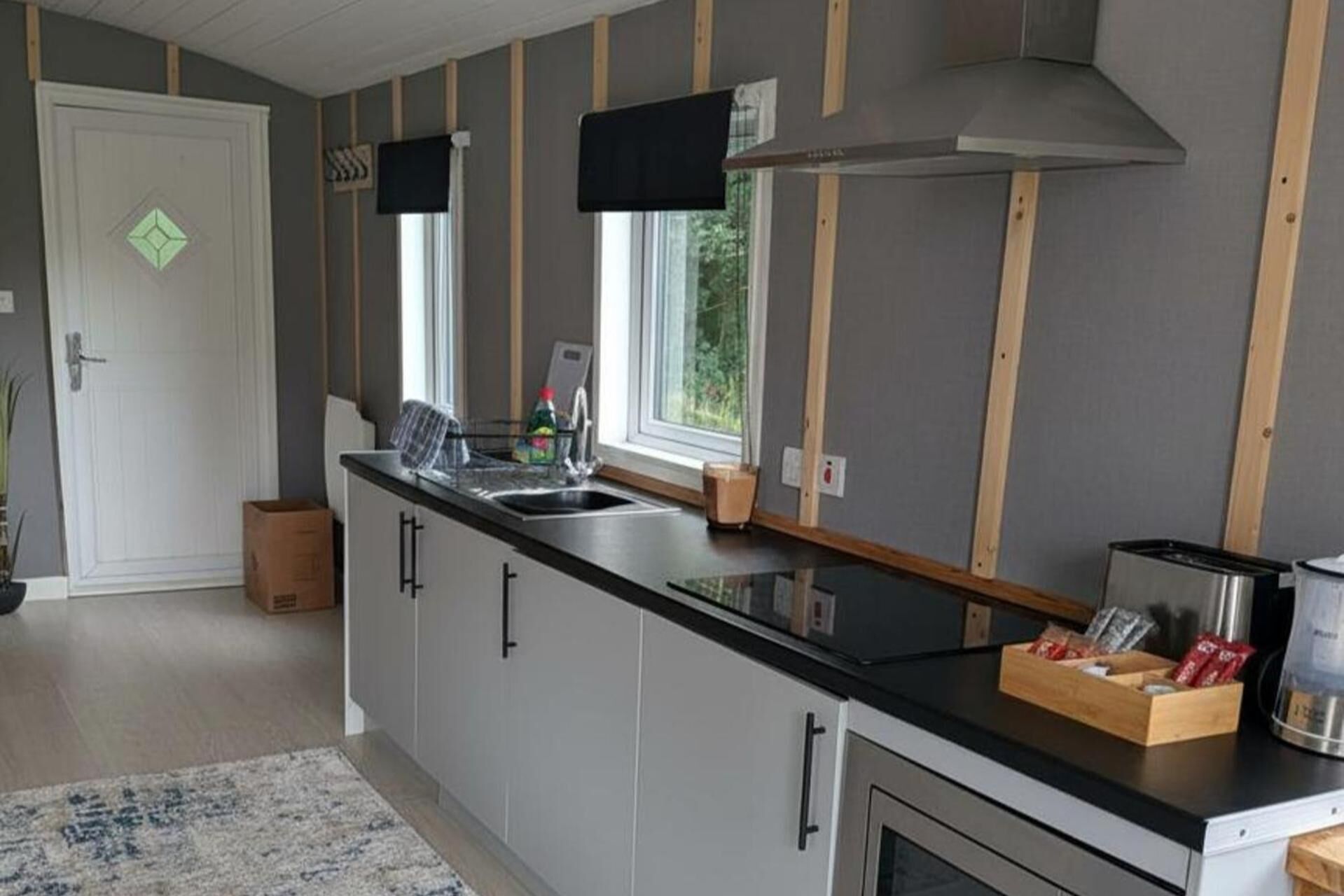 A modern kitchen with a large island, a built-in oven, and a window providing natural light.