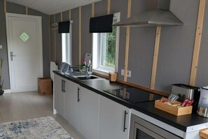 Uma cozinha moderna com uma ilha grande, forno embutido e uma janela que proporciona iluminação natural.