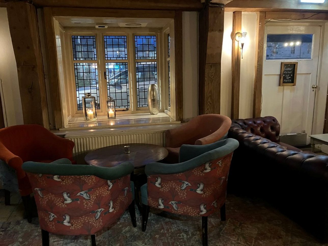 A cozy room with a fireplace, a window with a view, and a seating area with a table and chairs.