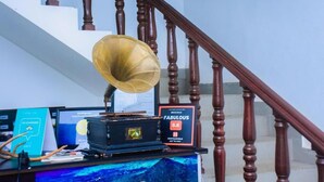 A desk with a vintage gramophone, a computer monitor, and a sign reading "Fabulous 8.6". - BEDBOX (Dambulla,)