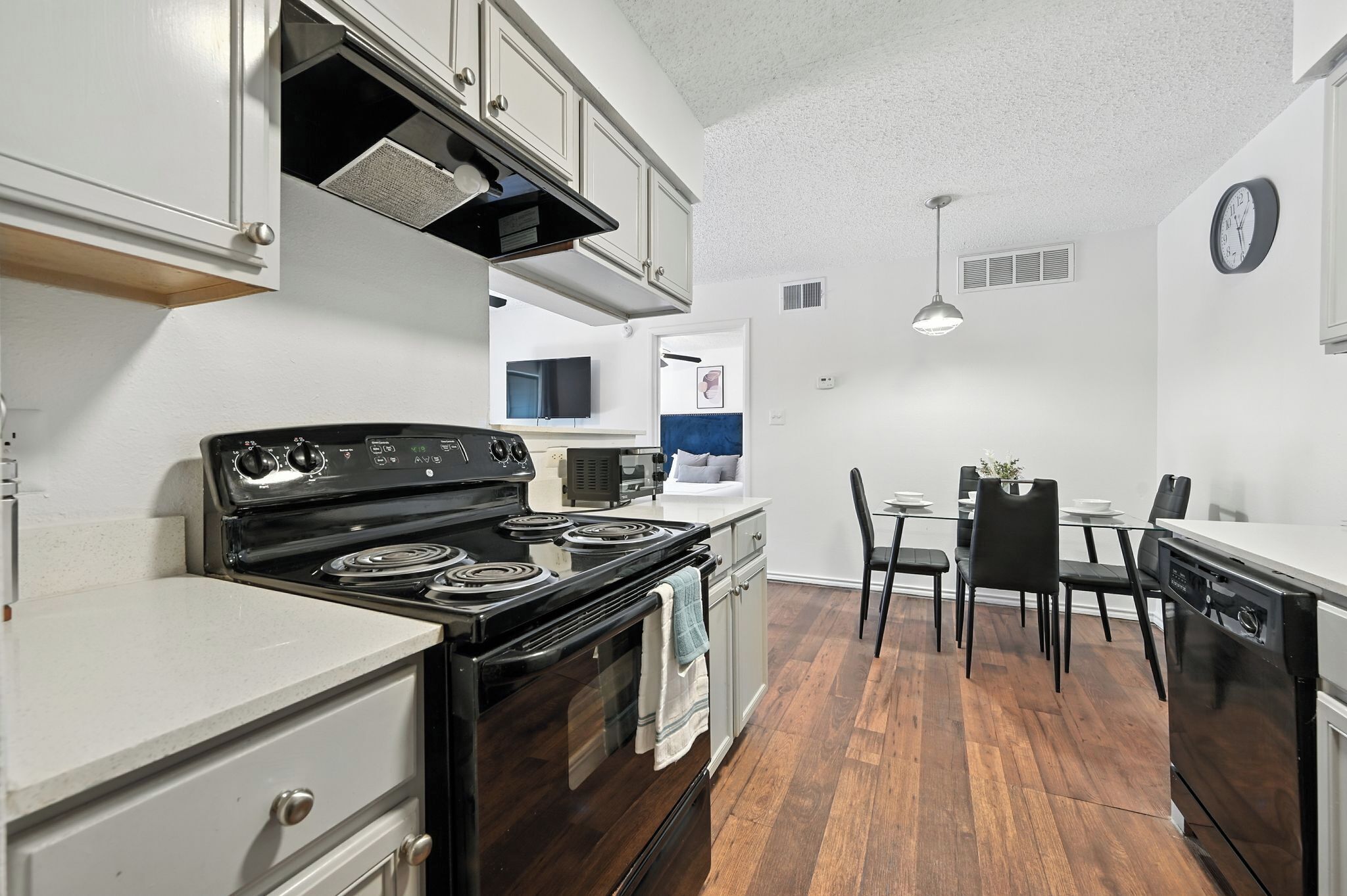Une cuisine équipée d’une cuisinière, d’un four et d’un coin repas avec des chaises et une table.