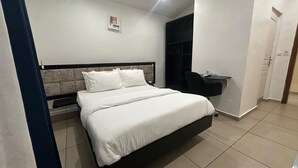 Ein ordentlich eingerichtetes Schlafzimmer mit Bett, Nachttisch und Schreibtisch mit Stuhl.