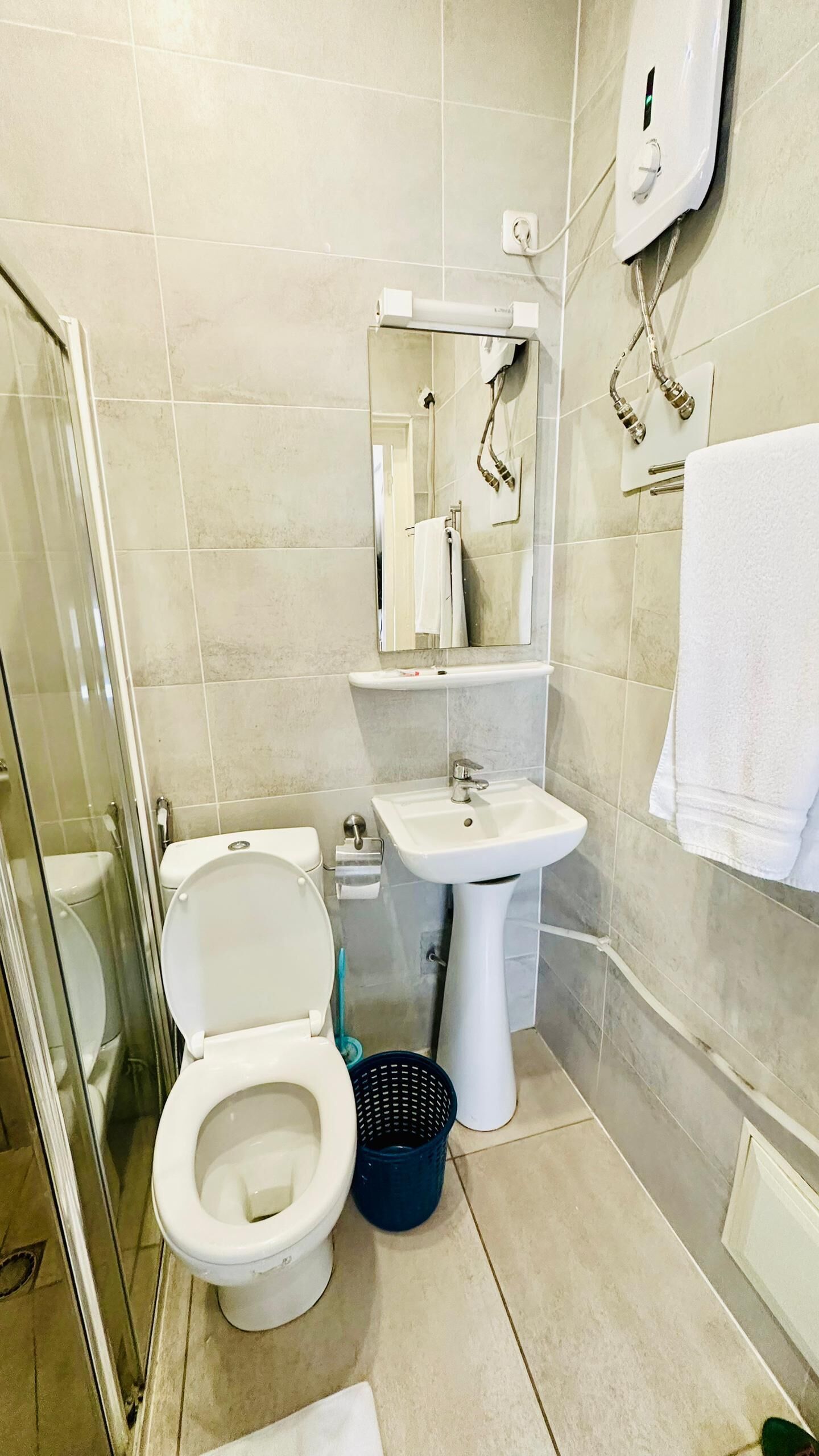 A bathroom with a toilet, sink, and shower.