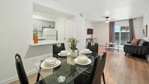 Un appartement moderne comprenant un coin repas, une cuisine et un espace de vie.