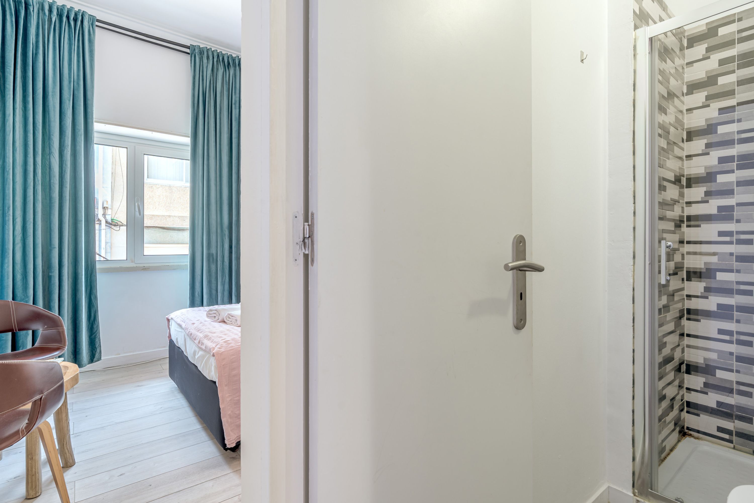 Une chambre à coucher comprenant un lit, une chaise, une porte et un espace douche.