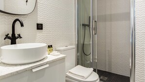 A modern bathroom with a white sink, a toilet, and a glass-enclosed shower. - Cosy Apartment - 2P - Exhibitions Park (Paris)