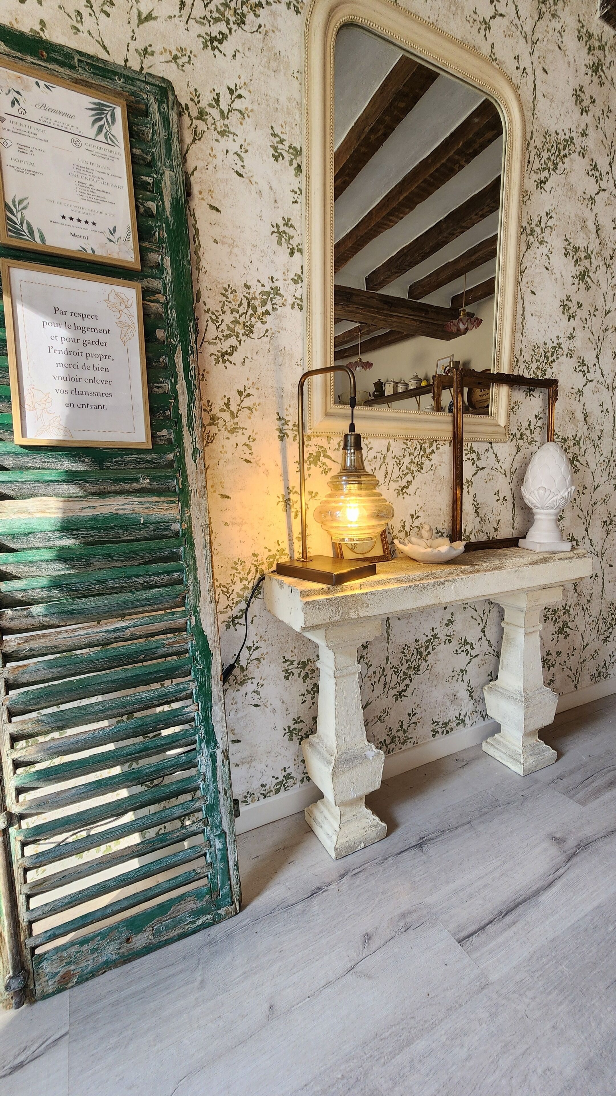 Une pièce au style rétro, avec un banc en bois, un miroir fixé au mur et une table avec une lampe.