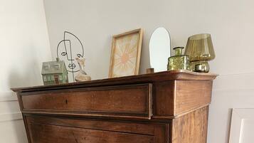 A wooden dresser with multiple drawers, a mirror, and decorative items on top.