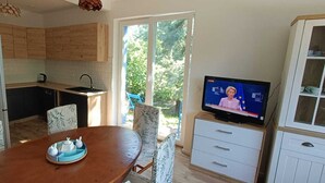 Ein kompakter Wohnbereich mit Küche, Essbereich und Fernseher.