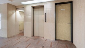 An elevator area with beige walls and a tiled floor. - Sleep Inn Gotanda (Tokyo)